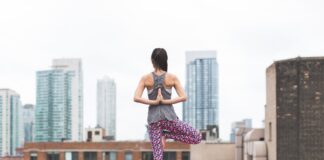 woman standing on pink yoga mat meditating 373946 scaled