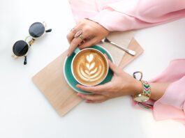 woman holding cup of latte 1260591 scaled